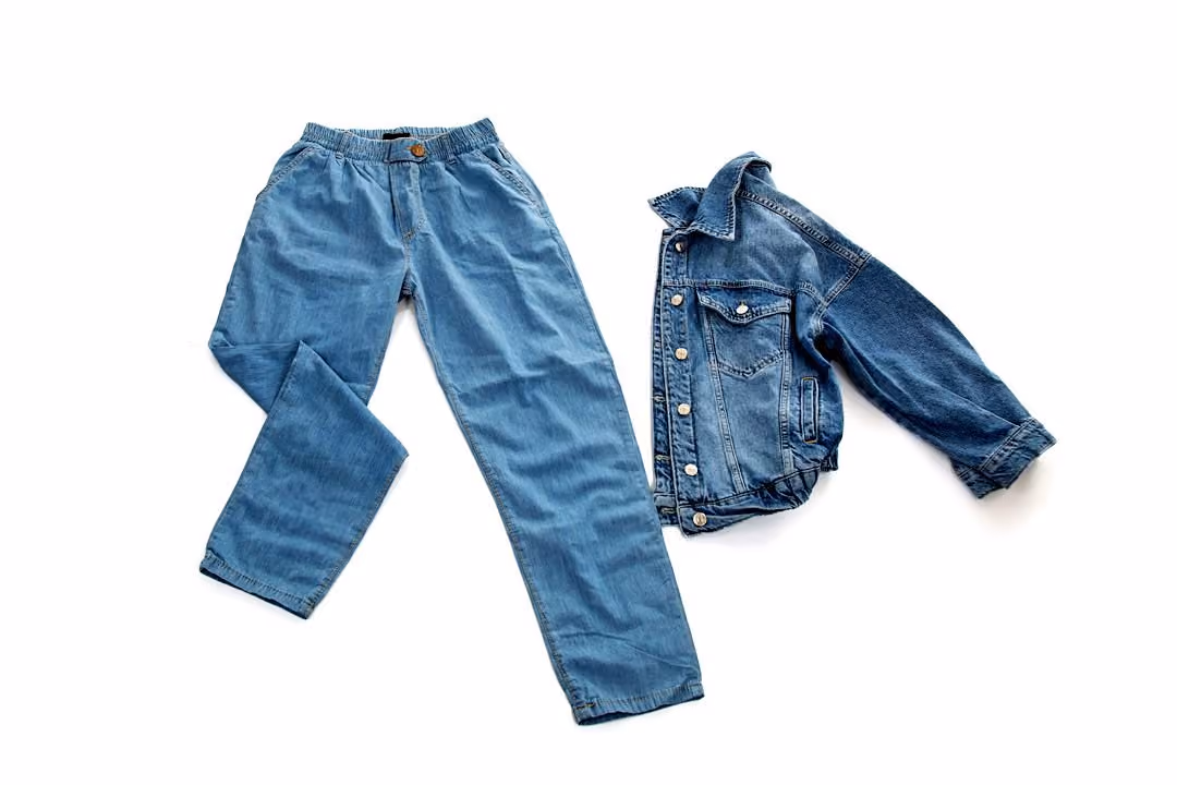 After: Blue jeans and denim jacket laid flat on a white background