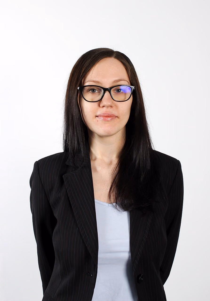 A corporate headshot of a woman in a black blazer after natural retouching