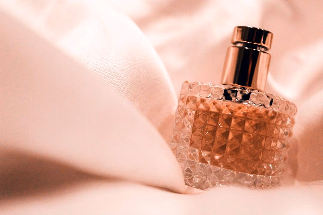 After: Pink glass perfume bottle on soft pink fabric