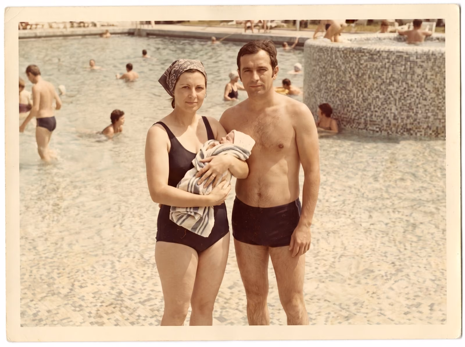 After: Couple holding a newborn by a swimming pool, restored from a heavily stained print