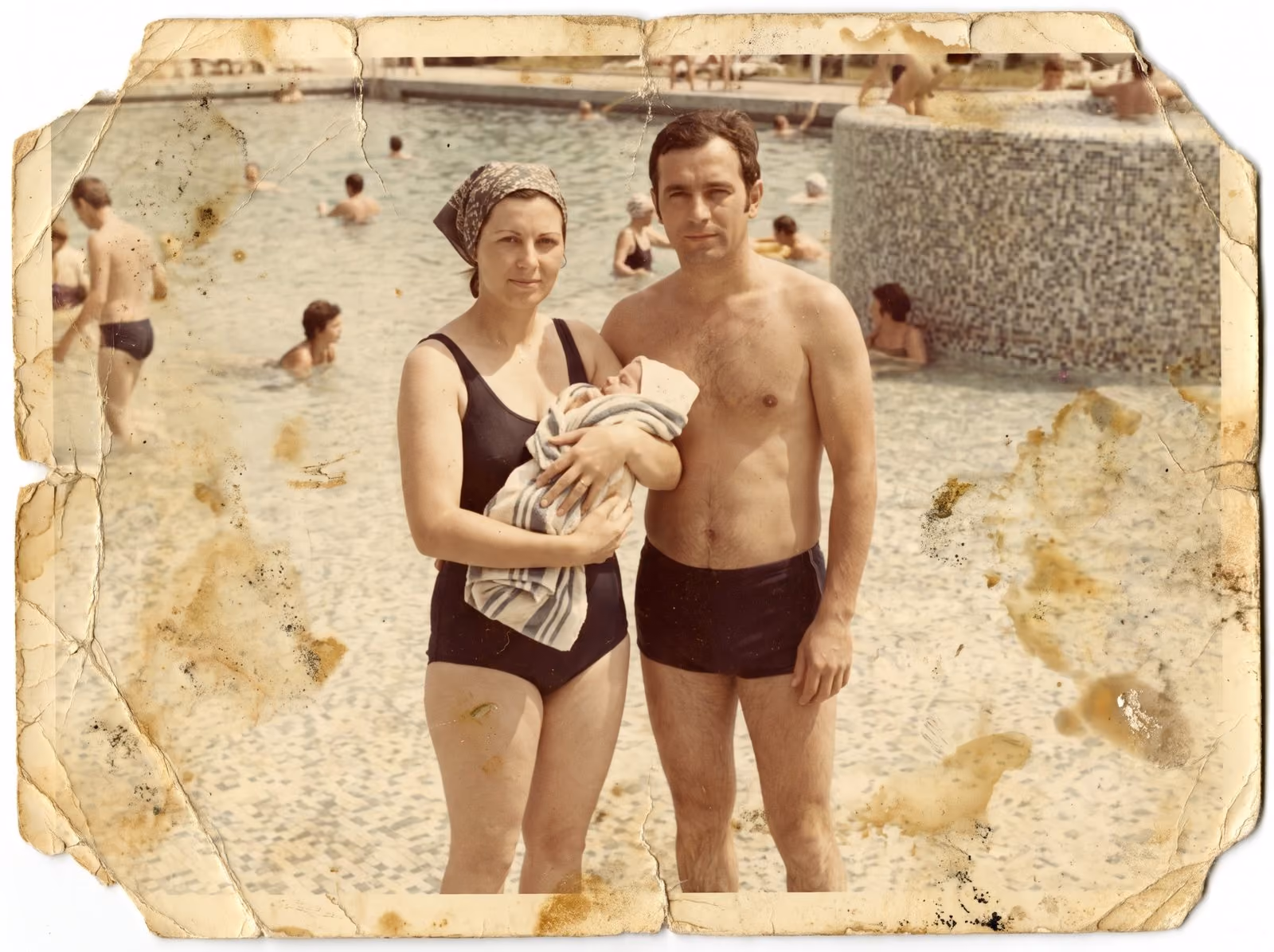 A family photograph of young parents with a newborn by a pool, stained and in need of care