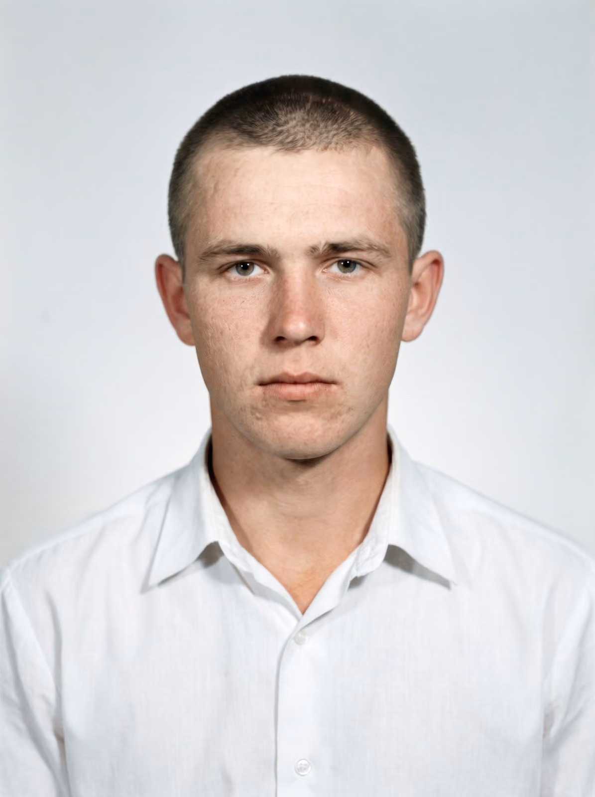 After: Portrait of a young man with a short haircut in a white shirt, restored from a cracked and stained print